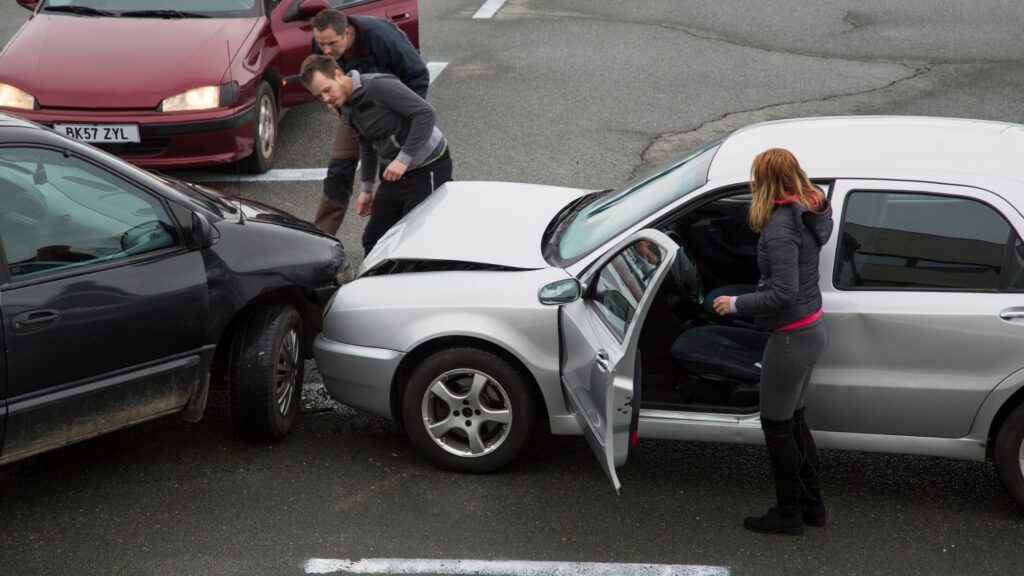 Two vehicles involved in a head-on collision in Mississippi, with concerned individuals examining the damage. The Ocean Springs Head-On Collision Lawyer is dedicated to helping accident victims understand their legal rights and pursue compensation for injuries and damages sustained in such accidents